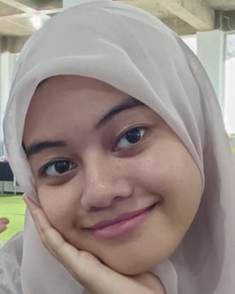 Syashi resting her chin on her hand, smiling