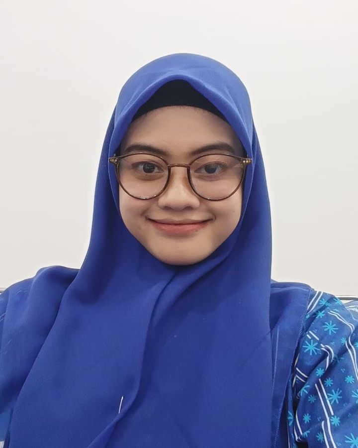 Syashi in a blue hijab and glasses
